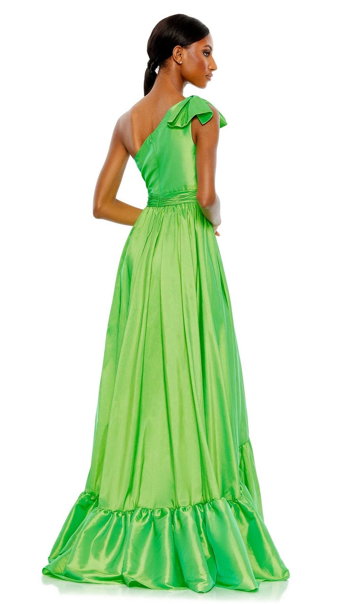 A woman stands facing away from the camera in the shiny bright green Long Formal Dress 68027 by Mac Duggal, featuring one shoulder and ruffle details.